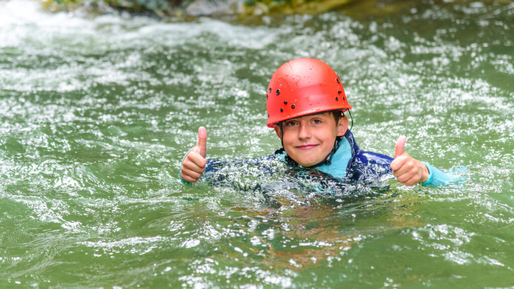 Enfant heureux pratiquant le canyoning dans les Pyrénées